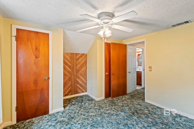 interior space featuring carpet flooring, a textured ceiling, ceiling fan, and wood walls