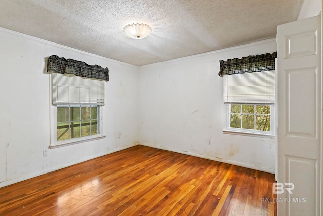 unfurnished room with wood-type flooring, a textured ceiling, and ornamental molding