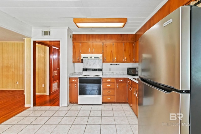 kitchen featuring decorative backsplash, ornamental molding, light hardwood / wood-style floors, white range with electric cooktop, and stainless steel refrigerator