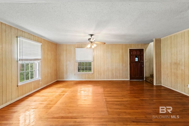 empty room featuring wood-type flooring and wooden walls