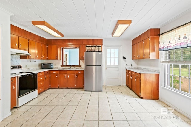 kitchen with stainless steel refrigerator, a wealth of natural light, ornamental molding, and electric stove