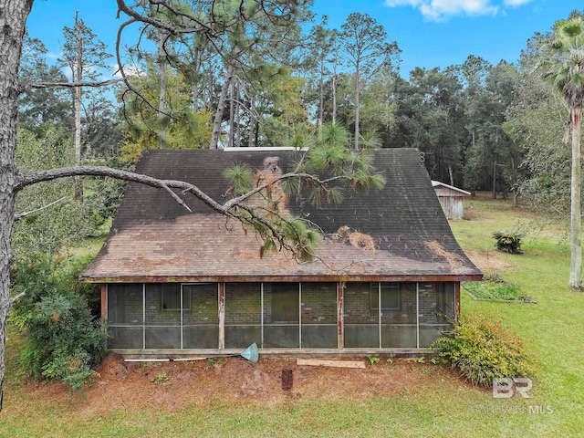 view of home's exterior featuring a lawn and a sunroom