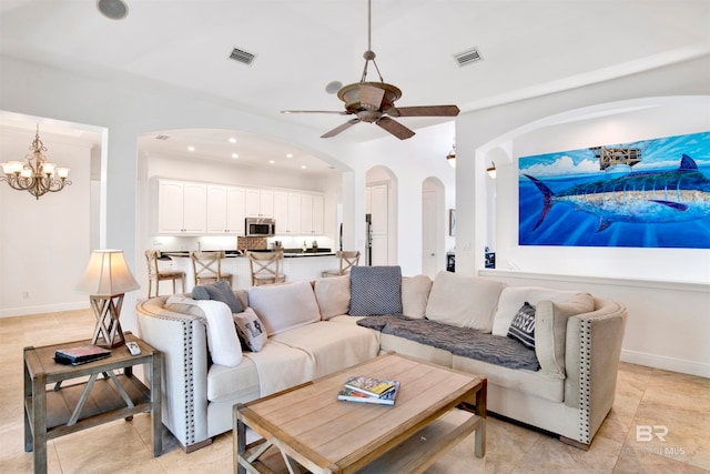 living room featuring ceiling fan with notable chandelier and light tile patterned floors