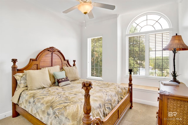 carpeted bedroom with ornamental molding and ceiling fan