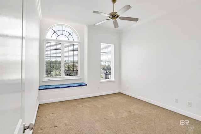 empty room featuring crown molding, light colored carpet, and ceiling fan