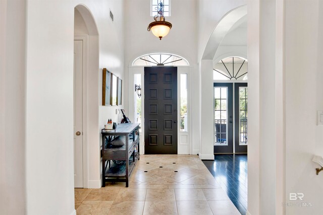 tiled foyer entrance with a towering ceiling