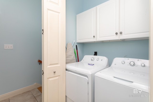 clothes washing area featuring light tile patterned floors, baseboards, cabinet space, and separate washer and dryer