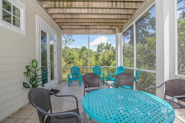 sunroom / solarium featuring outdoor dining area and french doors