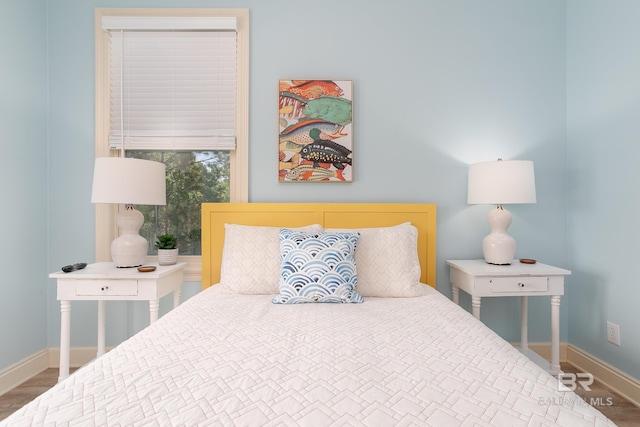 bedroom with baseboards and wood finished floors
