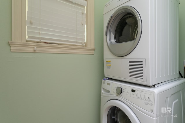 clothes washing area featuring laundry area and stacked washing maching and dryer