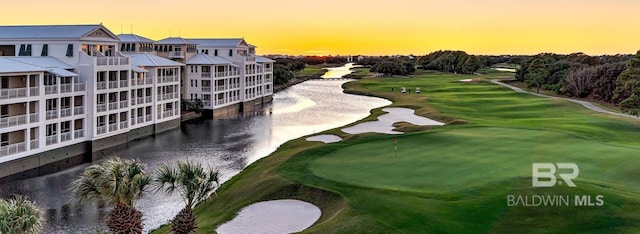 view of home's community with golf course view and a water view