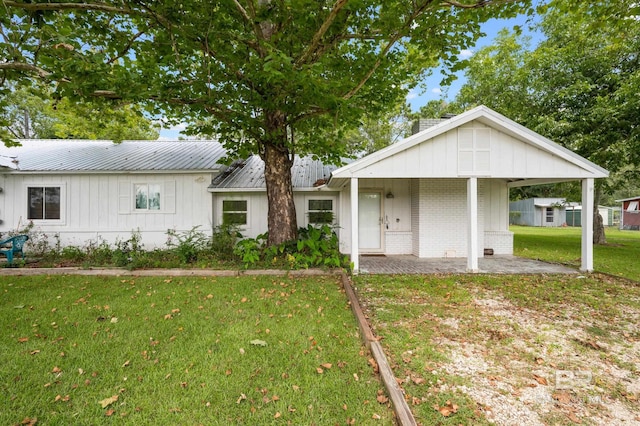 24663 Chestnut St Unit A & B, Elberta, AL 36530 - view of front of house with a front yard, covered porch, brick siding, metal roof, and board and batten siding