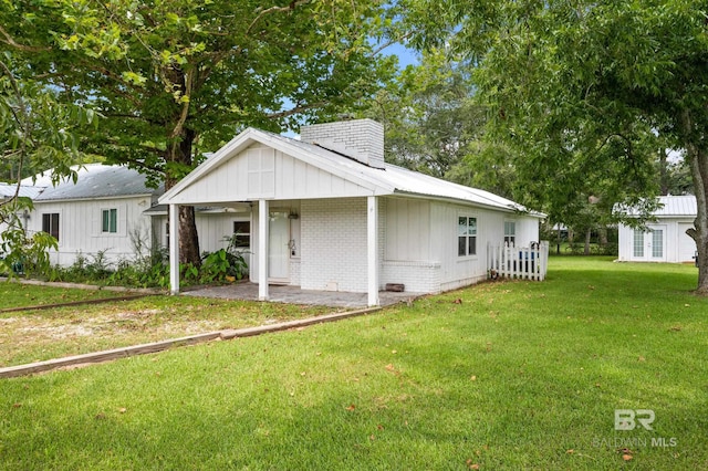 24663 Chestnut St Unit A & B, Elberta, AL 36530 - view of front of house featuring a chimney, a front yard, and brick siding