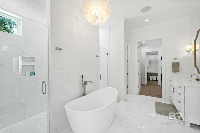 bathroom with marble finish floor, a shower stall, ornamental molding, and a freestanding tub