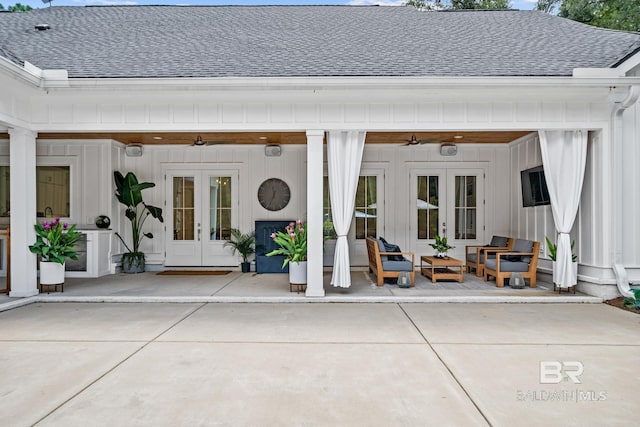 view of exterior entry featuring french doors, roof with shingles, and ceiling fan