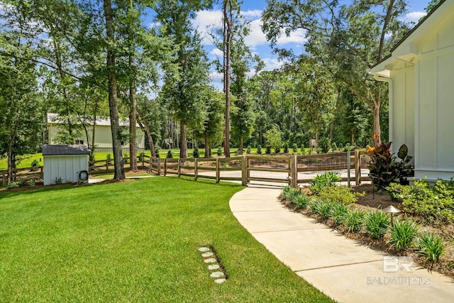 view of yard with a storage unit, fence, and an outbuilding