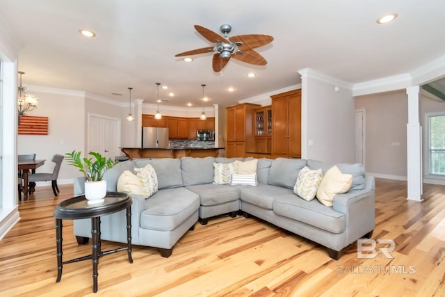 living room featuring ornamental molding, light wood-type flooring, and ceiling fan