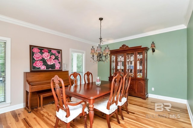 dining area featuring a chandelier, light wood-type flooring, and crown molding