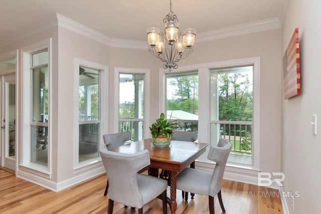 dining area with a healthy amount of sunlight, light wood-type flooring, and ornamental molding