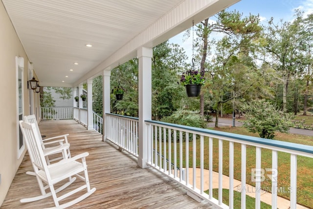 wooden deck with a lawn and covered porch