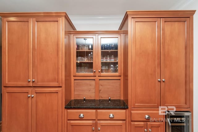 details featuring dark stone counters, bar, wine cooler, and crown molding