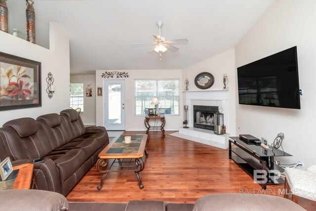 living room with ceiling fan, hardwood / wood-style floors, and a tile fireplace