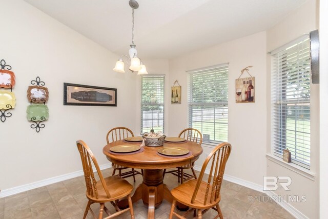 tiled dining space with a wealth of natural light and an inviting chandelier