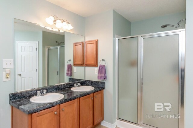 bathroom with a shower with shower door and vanity