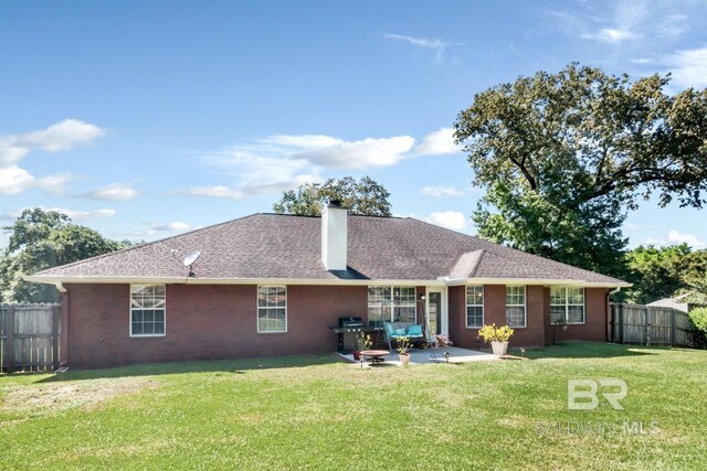 back of house with a patio area and a lawn