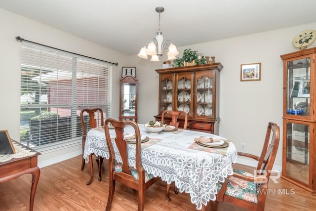 dining space featuring an inviting chandelier and light hardwood / wood-style flooring