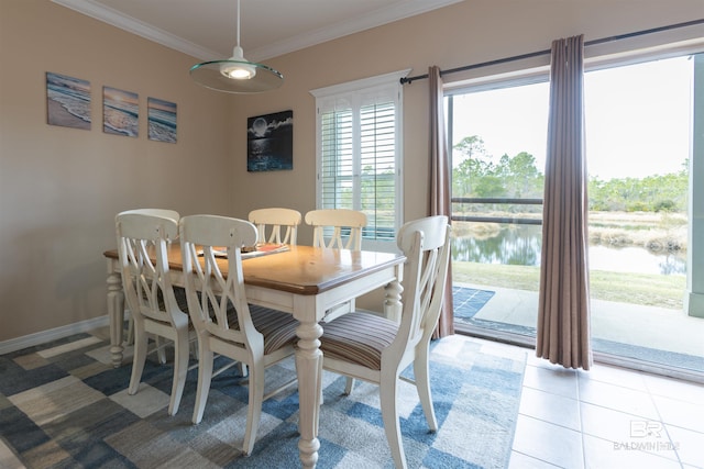 dining space with light tile patterned floors, a water view, baseboards, and ornamental molding