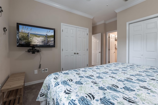 bedroom with baseboards, two closets, dark carpet, and crown molding