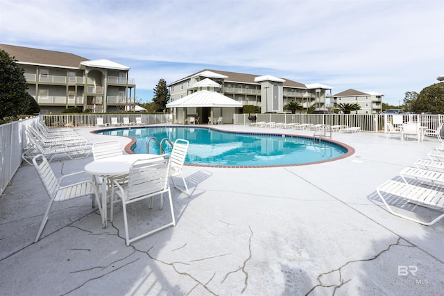 pool with a patio and fence