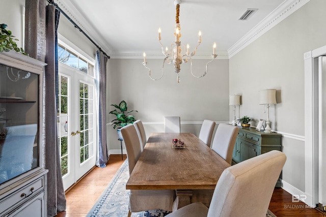 dining space with french doors, an inviting chandelier, a wealth of natural light, and hardwood / wood-style flooring