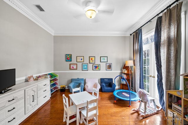 sitting room featuring ceiling fan, ornamental molding, and dark wood-type flooring