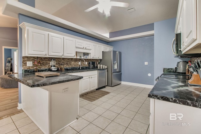 10675 Aloe Ln, Lillian, AL 36549 - kitchen with stainless steel appliances, light tile patterned flooring, a peninsula, a ceiling fan, and tasteful backsplash