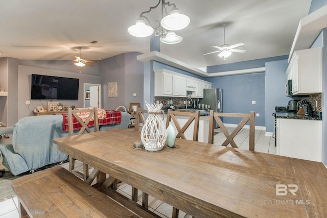 10675 Aloe Ln, Lillian, AL 36549 - dining area with ceiling fan, vaulted ceiling, light tile patterned floors, and baseboards