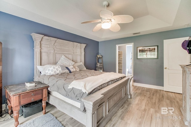 10675 Aloe Ln, Lillian, AL 36549 - bedroom with light wood-style flooring, a tray ceiling, baseboards, and ceiling fan
