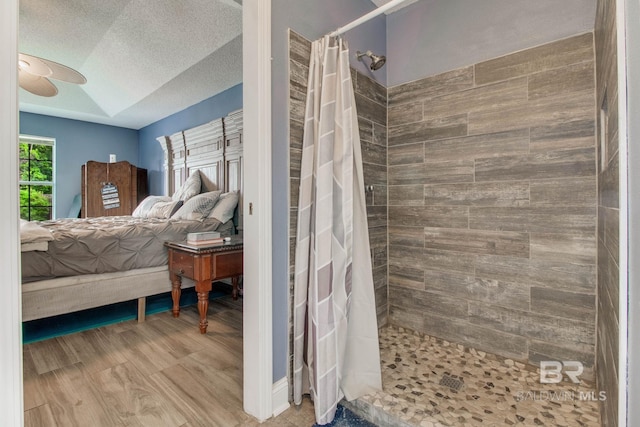 10675 Aloe Ln, Lillian, AL 36549 - ensuite bathroom with tiled shower, ceiling fan, and a textured ceiling