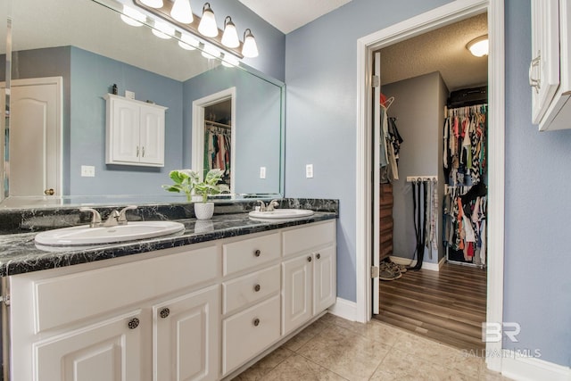 10675 Aloe Ln, Lillian, AL 36549 - bathroom with tile patterned floors, double vanity, a walk in closet, and baseboards