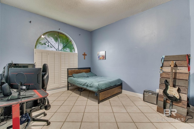 10675 Aloe Ln, Lillian, AL 36549 - bedroom with a desk, a textured ceiling, light tile patterned floors, and baseboards