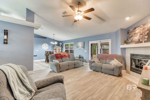 10675 Aloe Ln, Lillian, AL 36549 - living area with vaulted ceiling, a fireplace, ceiling fan, wood finished floors, and a chandelier
