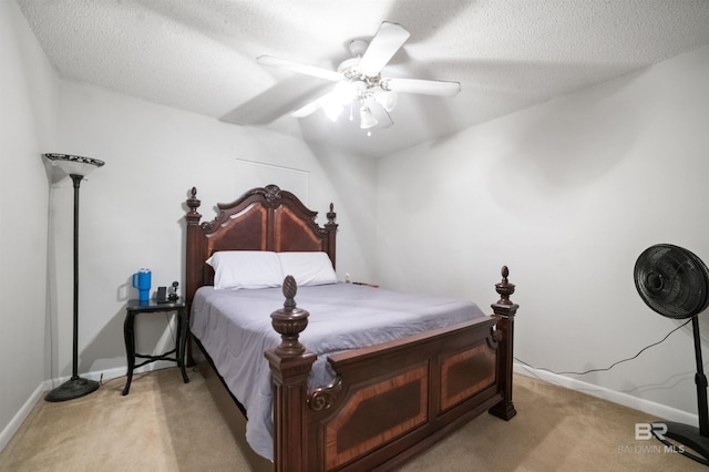 carpeted bedroom with ceiling fan and a textured ceiling