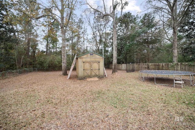 view of yard with a trampoline and a storage shed