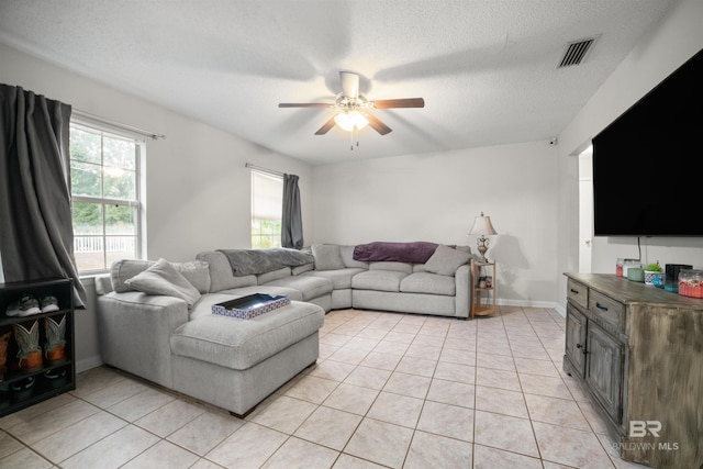 tiled living room featuring ceiling fan and a textured ceiling