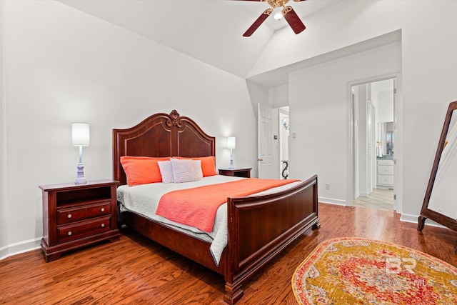 bedroom featuring baseboards, lofted ceiling, wood finished floors, ensuite bath, and a ceiling fan