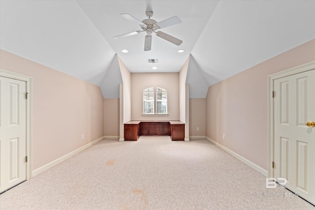 additional living space featuring baseboards, light carpet, ceiling fan, and vaulted ceiling