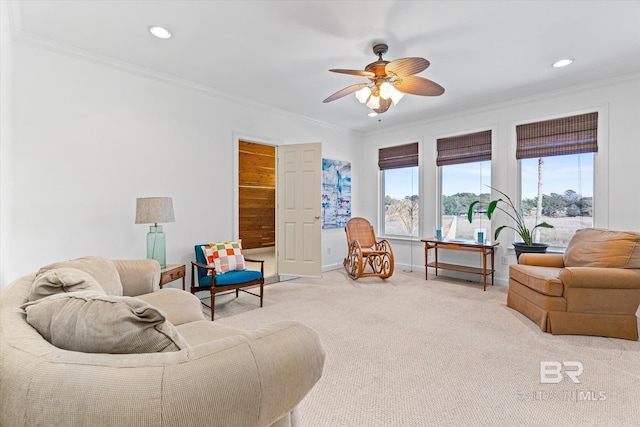 living room with crown molding, light colored carpet, baseboards, and ceiling fan