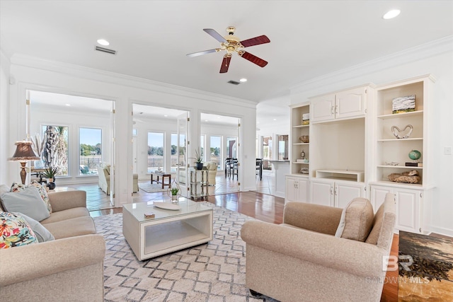 living area with visible vents, recessed lighting, a ceiling fan, and ornamental molding