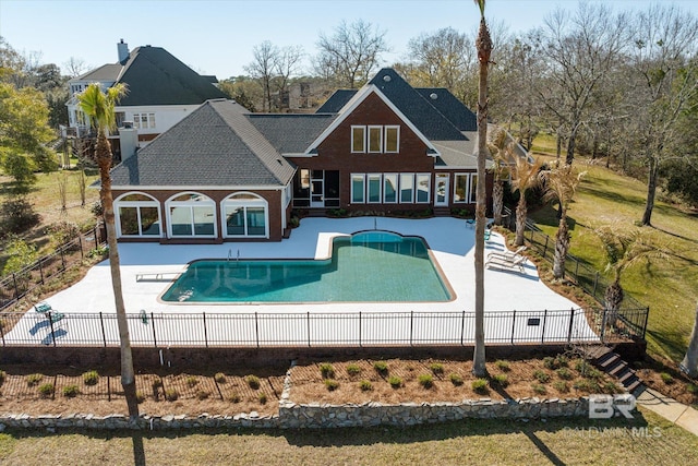 rear view of house featuring a fenced in pool, a patio, and fence